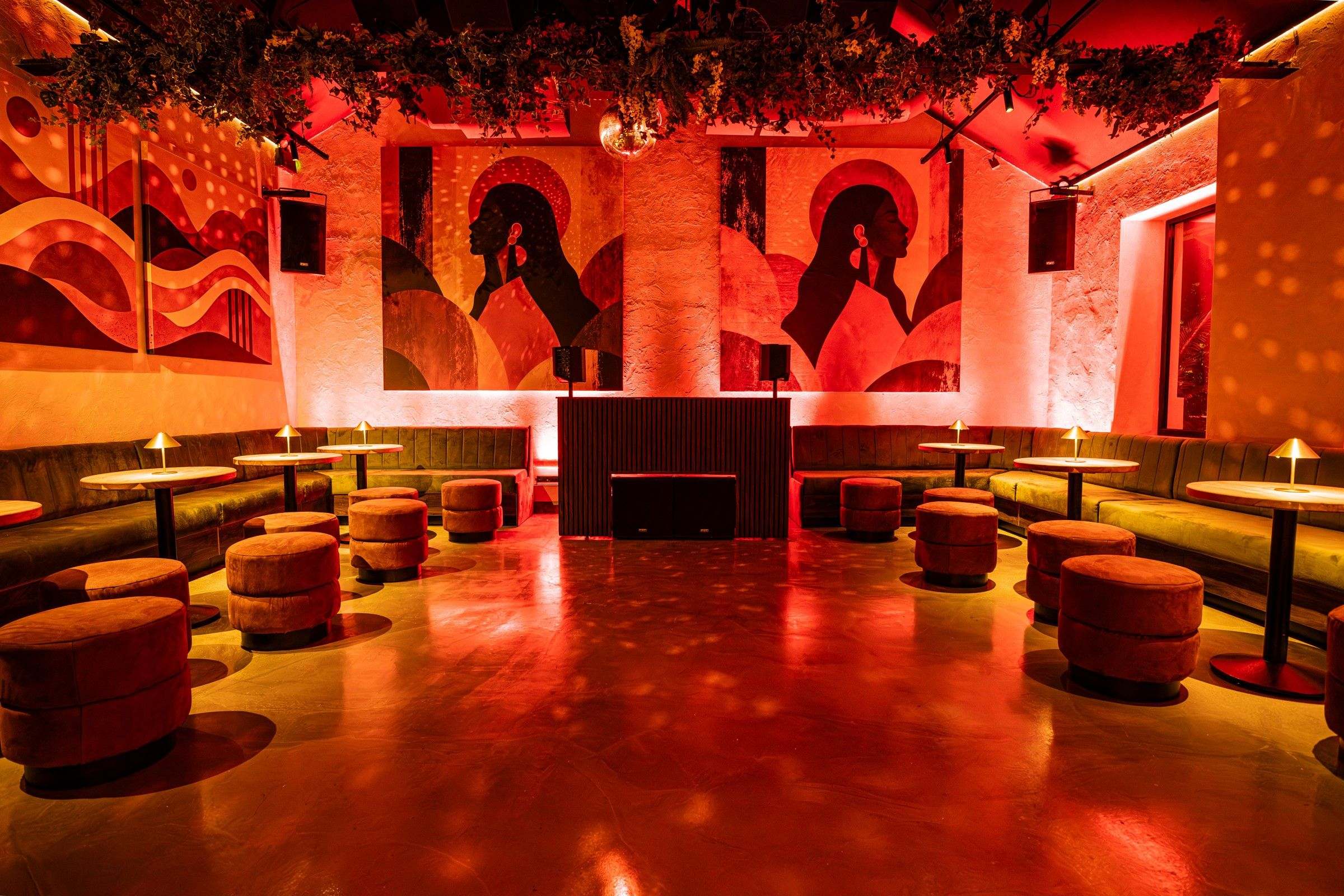 The room in red light, mirror-ball light across the floor