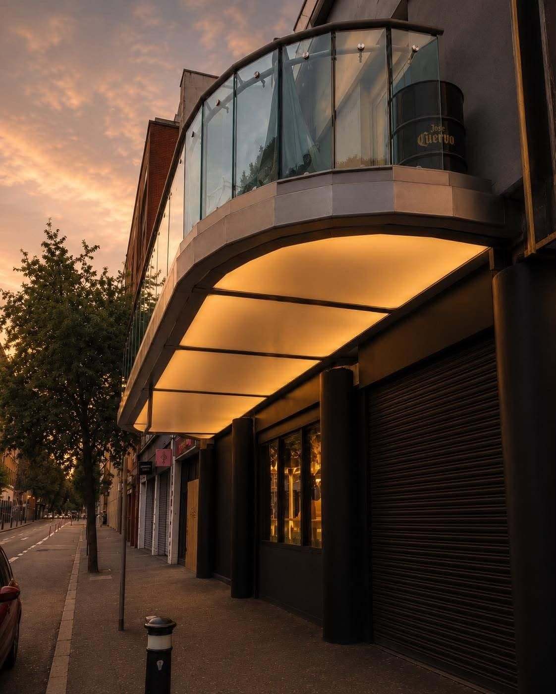 The canopy glowing over the entrance at dusk